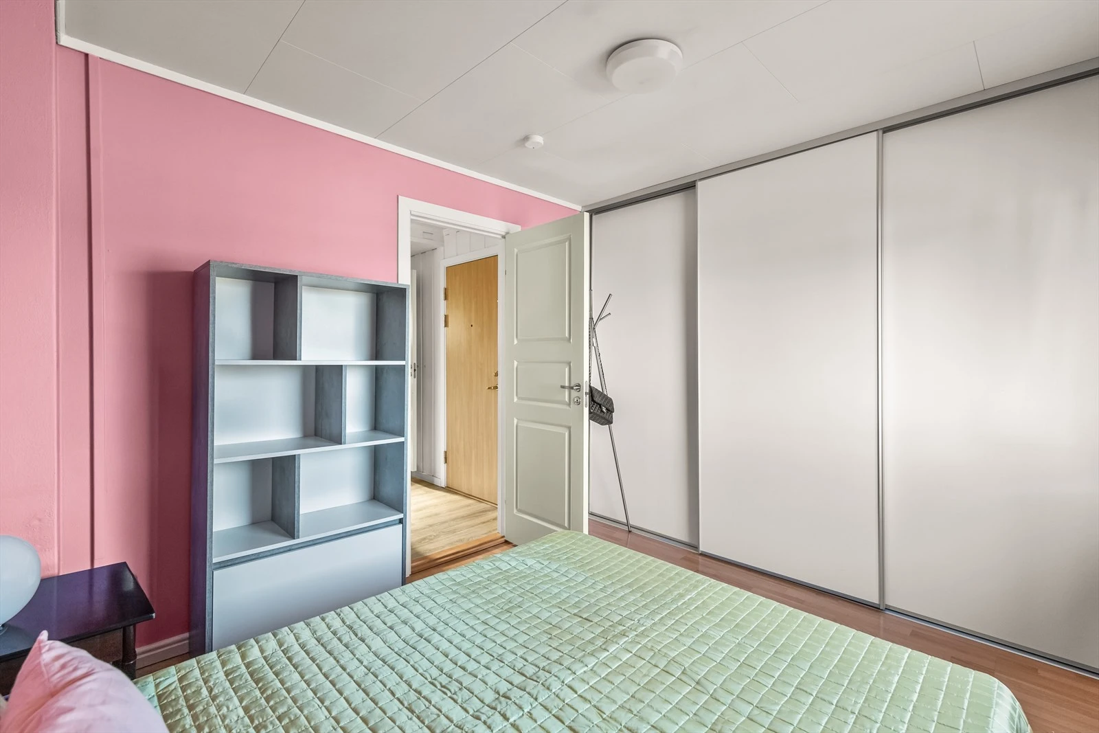 Stort soverom med skyvedørsgarderobe.