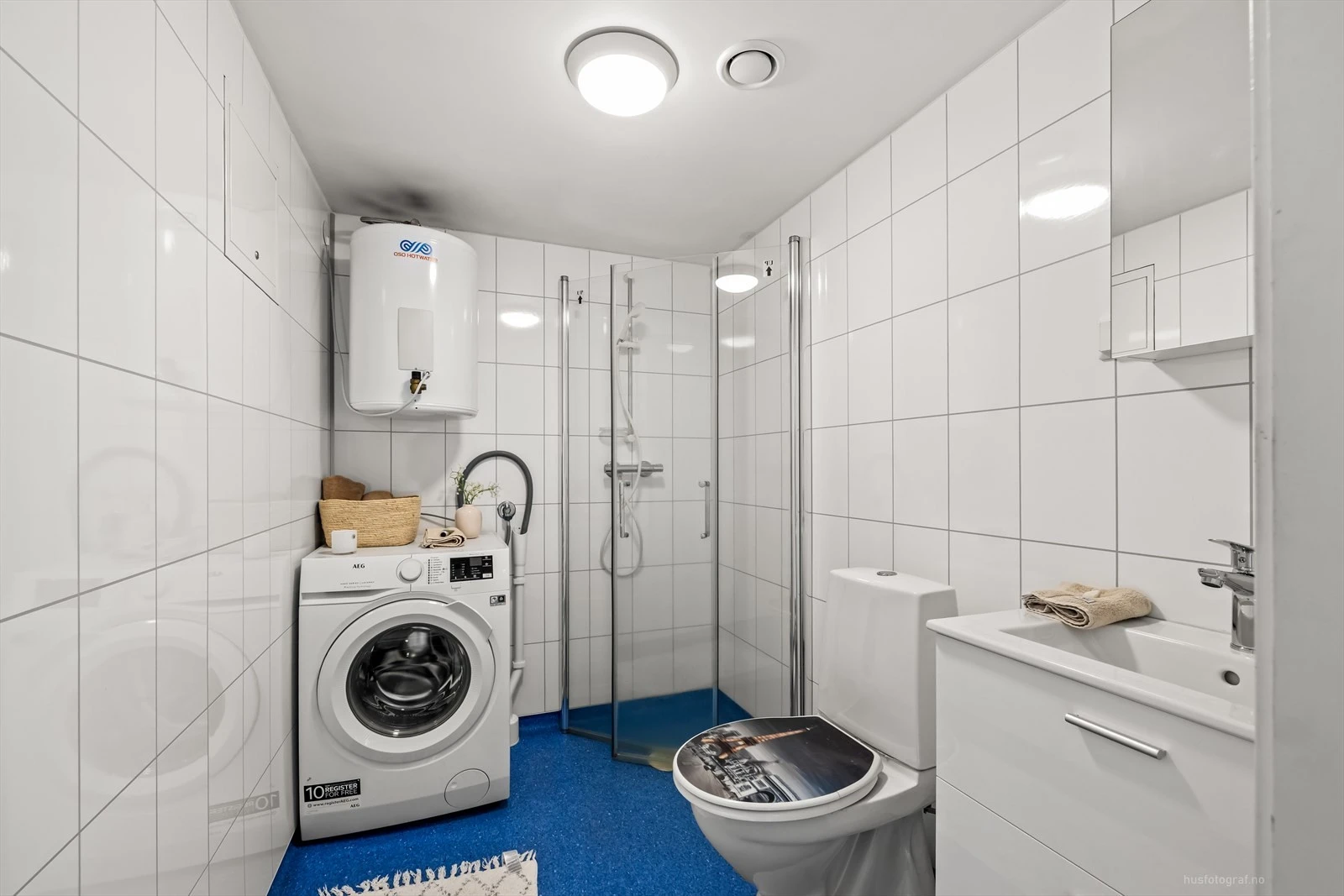 Moderne baderomsinnredning med opplegg for vaskemaskin.