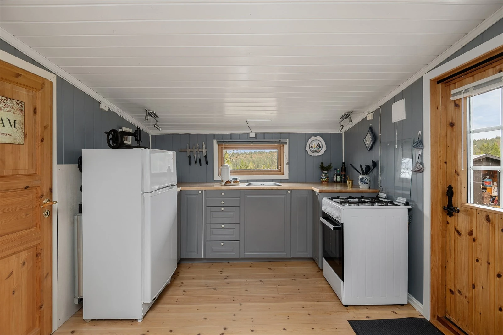 Innredningen er malt i farge som går ton i ton med veggene, noe som gir et helhetlig preg . Plass til kjøleskap og komfyr. Galleribilde