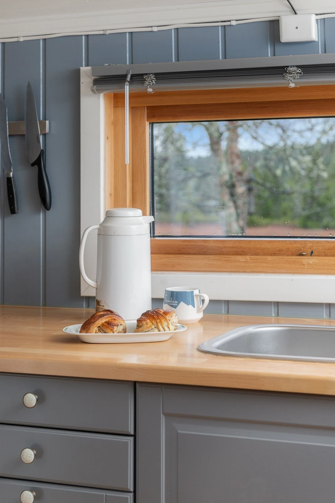 Fint lys inn over kjøkkenbenken gjennom vindu. Galleribilde