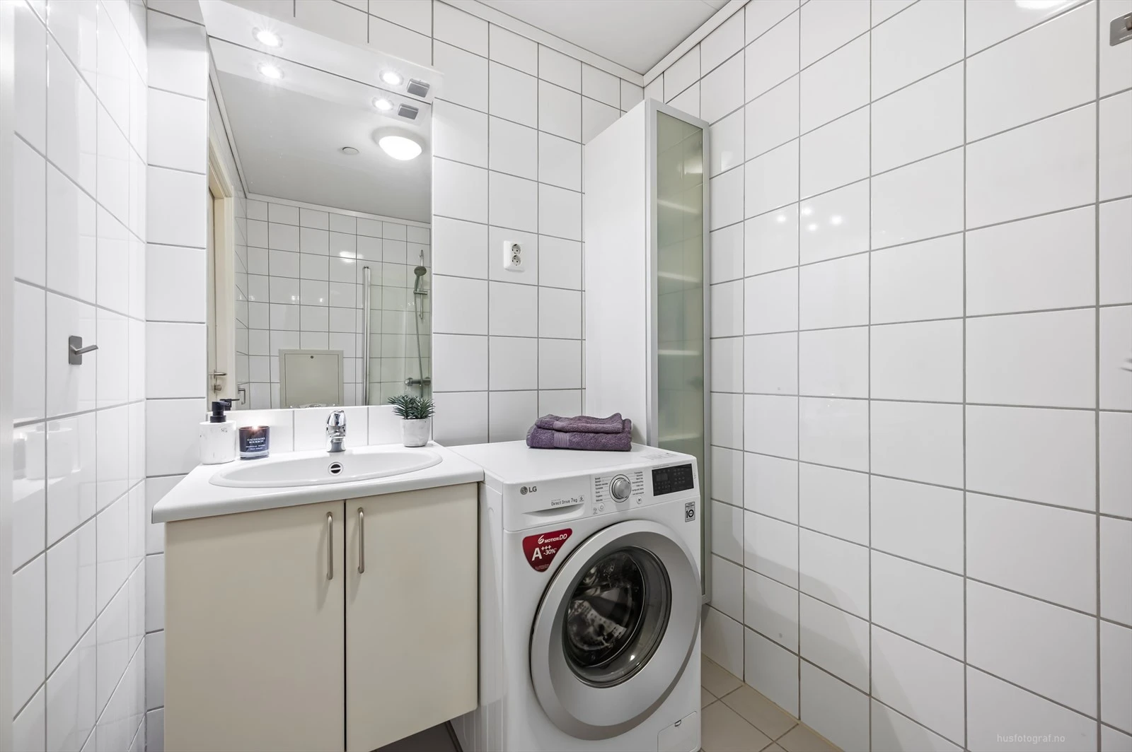 Moderne baderomsinnredning med opplegg for vaskemaskin.