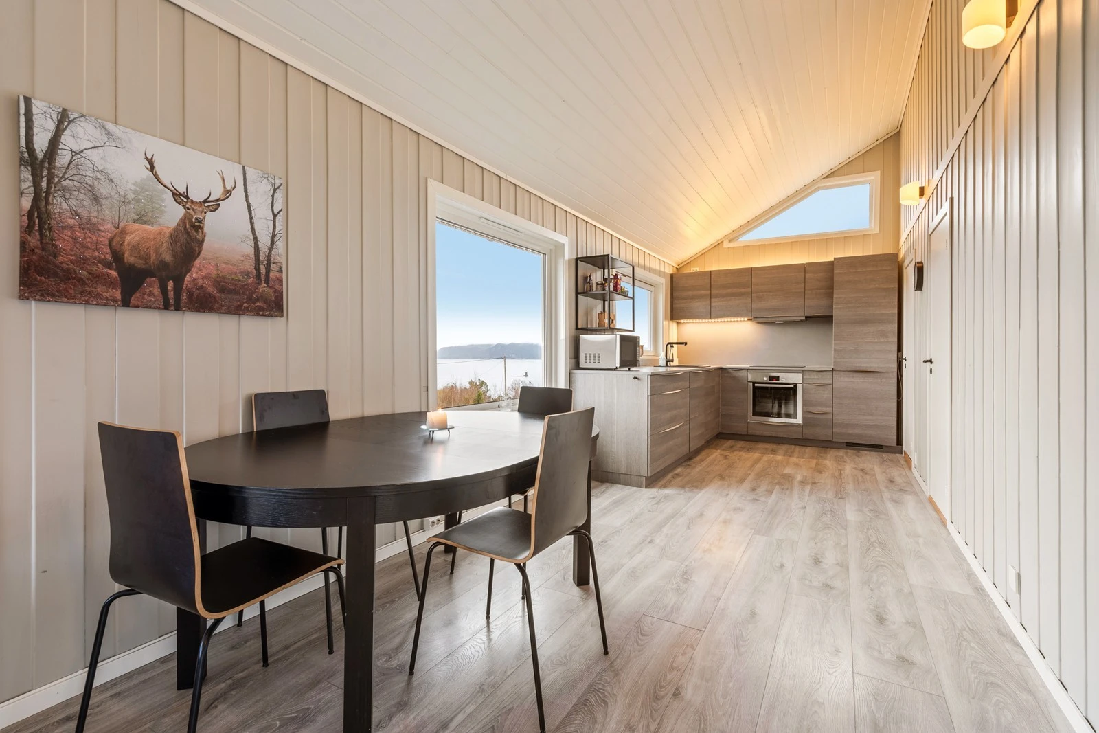 Boligen har åpen stue og kjøkkenløsning som gir et sosialt å hyggelig rom Galleribilde