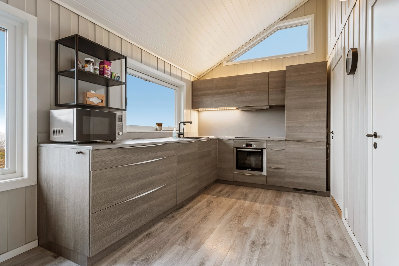 Pen kjøkkeninnredning med god skap og benkeplass Galleribilde