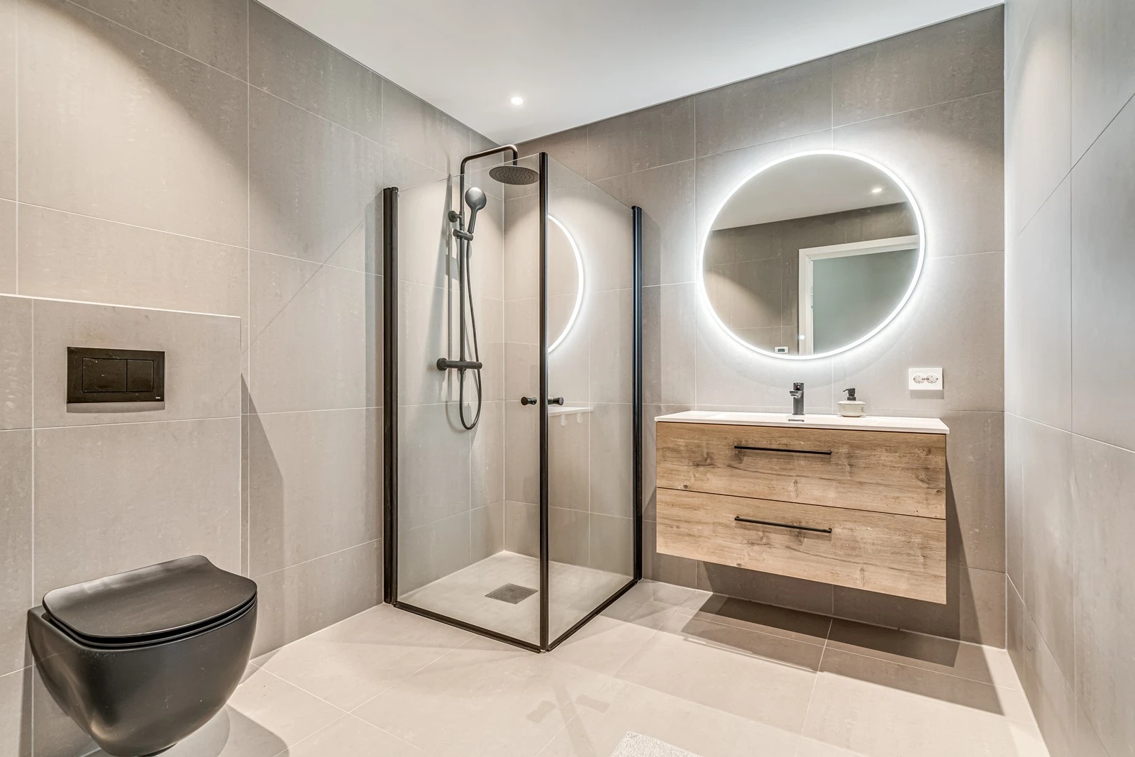 Rommelig og delikat baderom med dusjhjørne, vegghengt toalett og servant i seksjon. Galleribilde