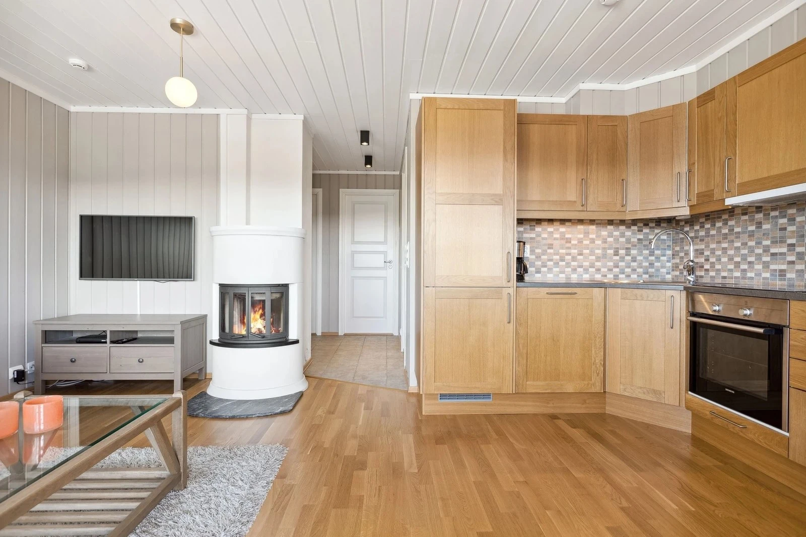 Midt i rommet finner du en stilfull peisinnsats som gir god varme og skaper en hyggelig og lun stemning Galleribilde