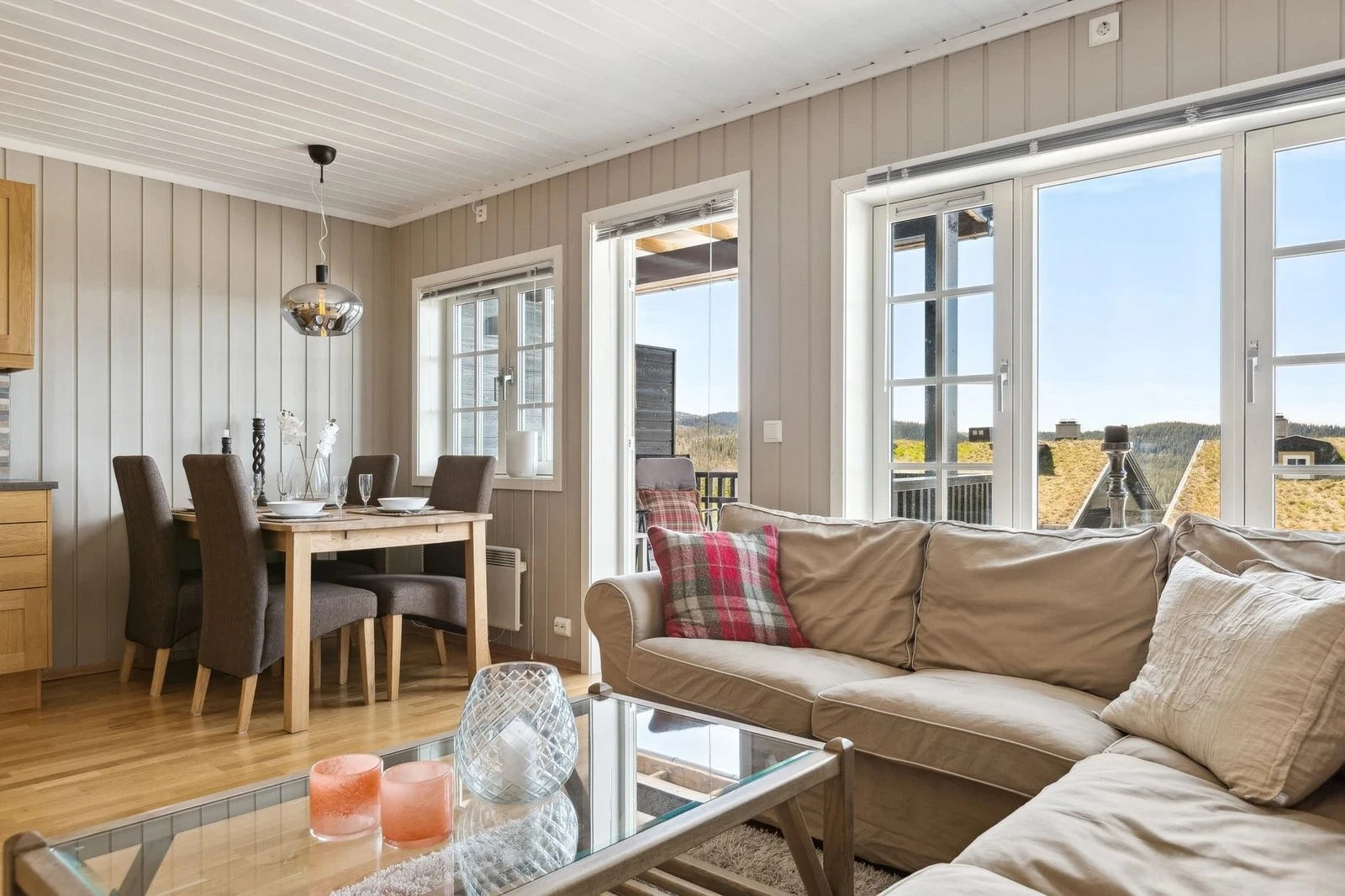 Her er det godt med plass til både sofa og spisegruppe. De store vinduene fremhever den flotte utsikten og slipper inn rikelig med dagslys Galleribilde