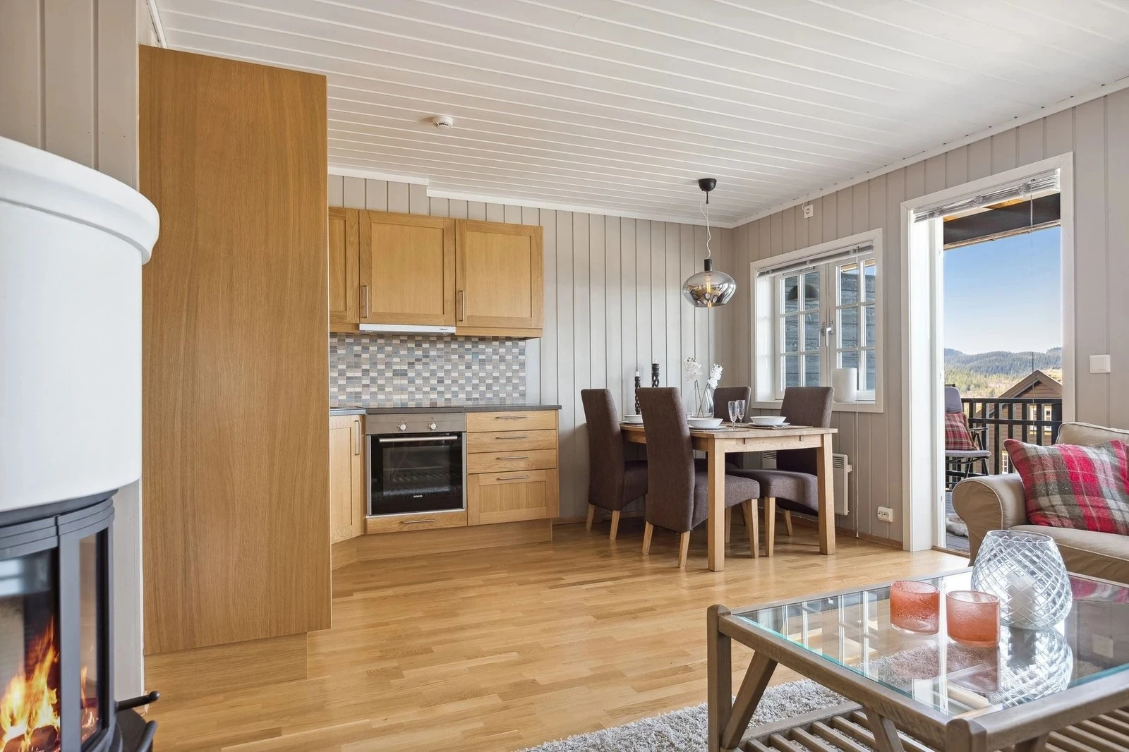 Åpen stue- og kjøkkenløsning som gjør rommet til et svært sosialt oppholdsrom Galleribilde