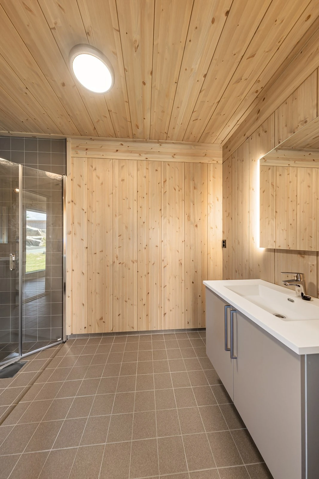 Badet har flislagt gulv med varmekabler og inneholder dusjhjørne, wc, servant med underskap og speil samt opplegg til vaskemaskin. Det er satt inn vaskemaskin på hytta, denne medfølger kun etter egen avtale meg selger Galleribilde