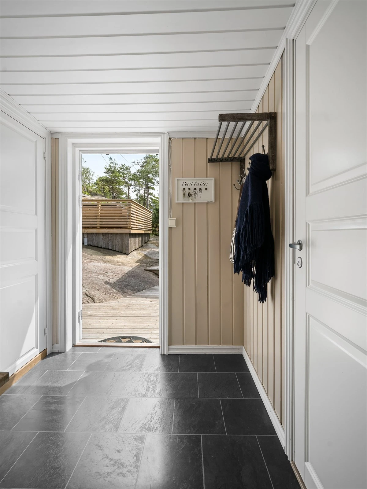 Det er plass til garderobemøbler eller knaggrekker på to sider av entreen. Gulvet er av flis-mønstret laminat. Galleribilde