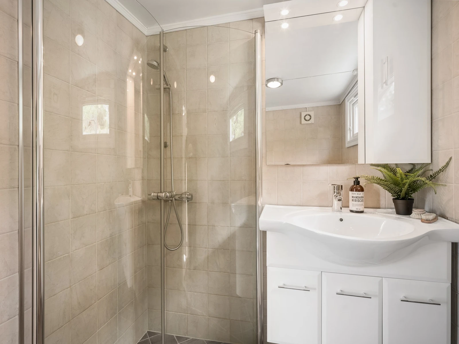 Badets areal er effektivt utnyttet; dusjdørene kan svinges inn for å maksimere den tilgjengelige gulvflaten. Galleribilde