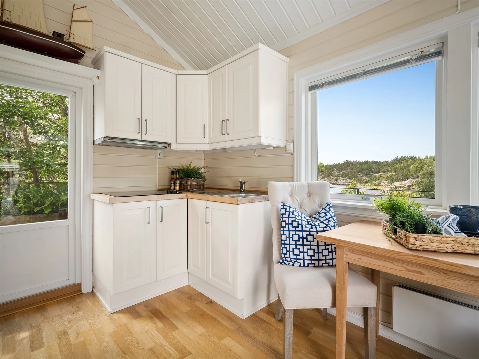 Kjøkkeninnredningen er kompakt, men likevel utstyrt med integrert platetopp og avtrekk. Galleribilde