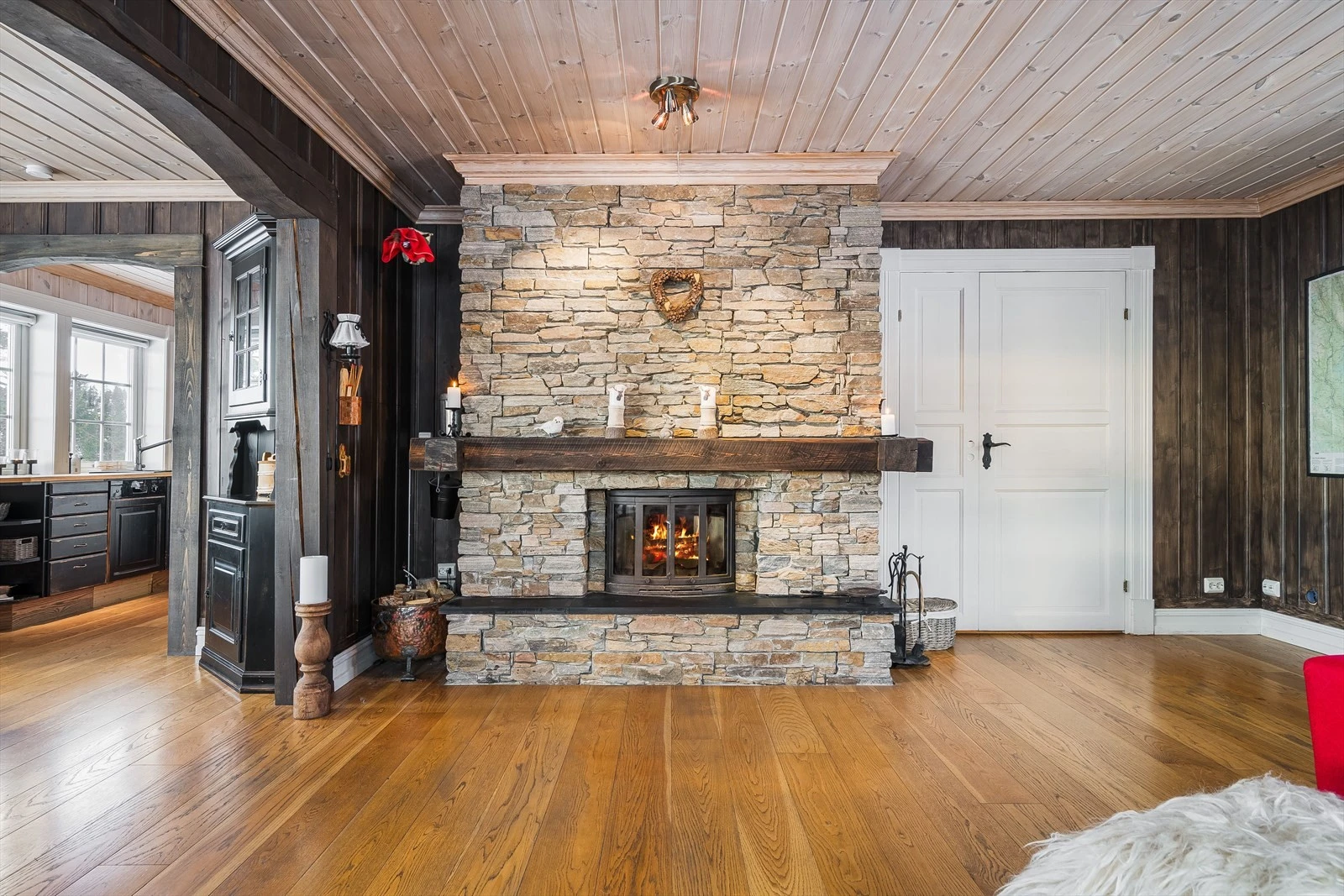 Som et fint midtpunkt i stuen er det en flott peis med naturstein og peisinnsats. Det er montert vifte i pipe for bedre trekk Galleribilde