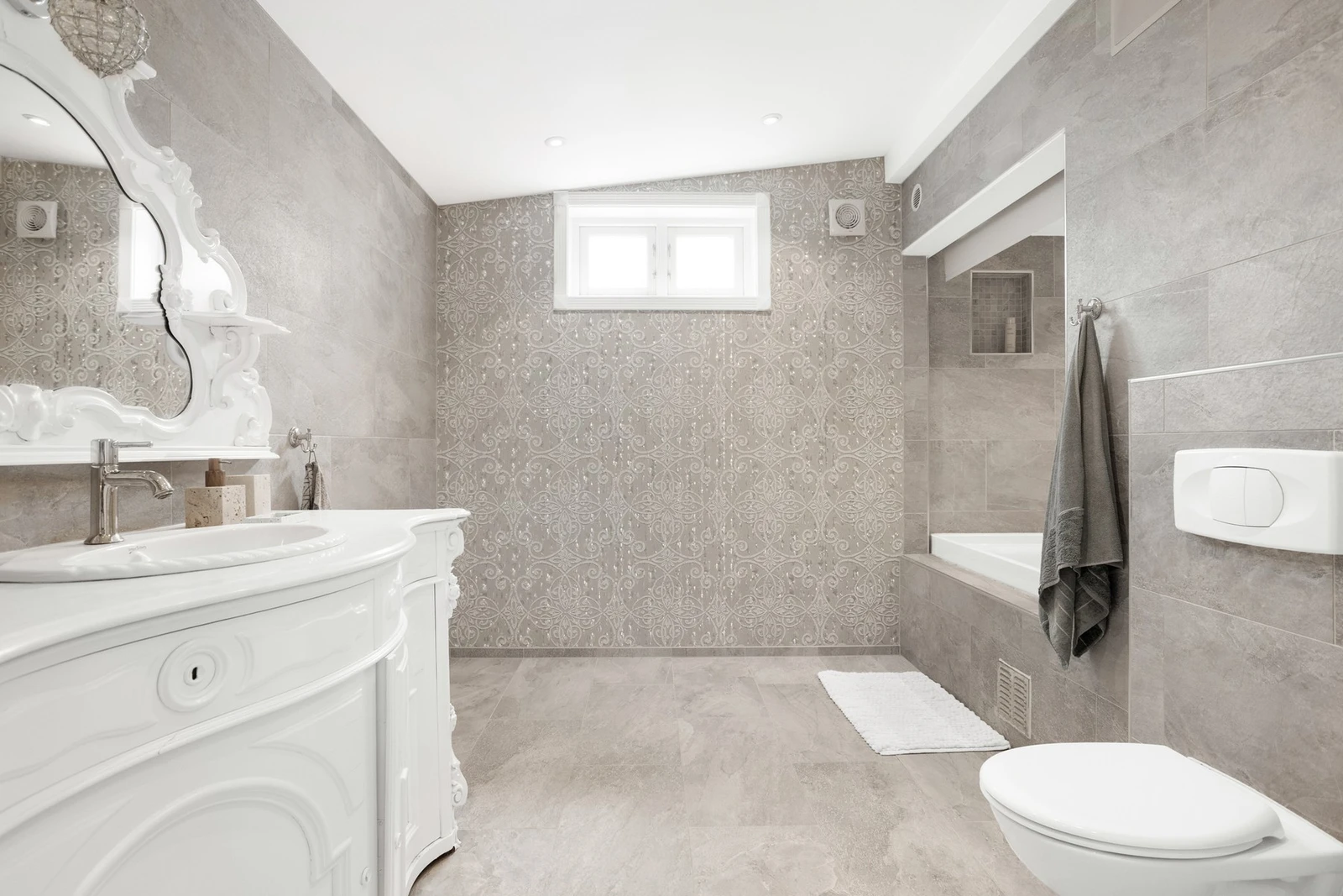 Baderommet er møblert med servant, vegghengt toalett og dusj Galleribilde