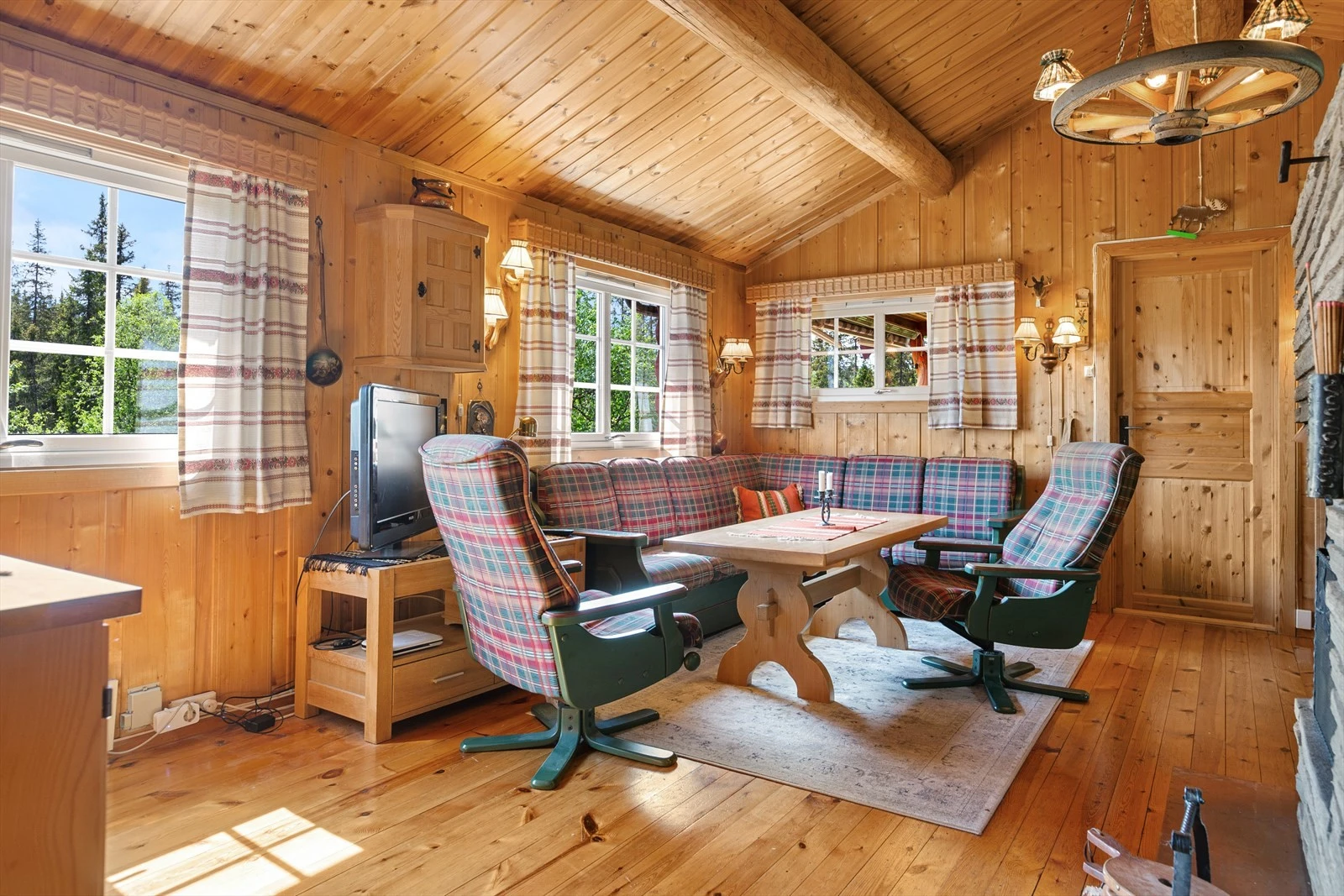 Stue med rausta himling og panelte overflater. Galleribilde