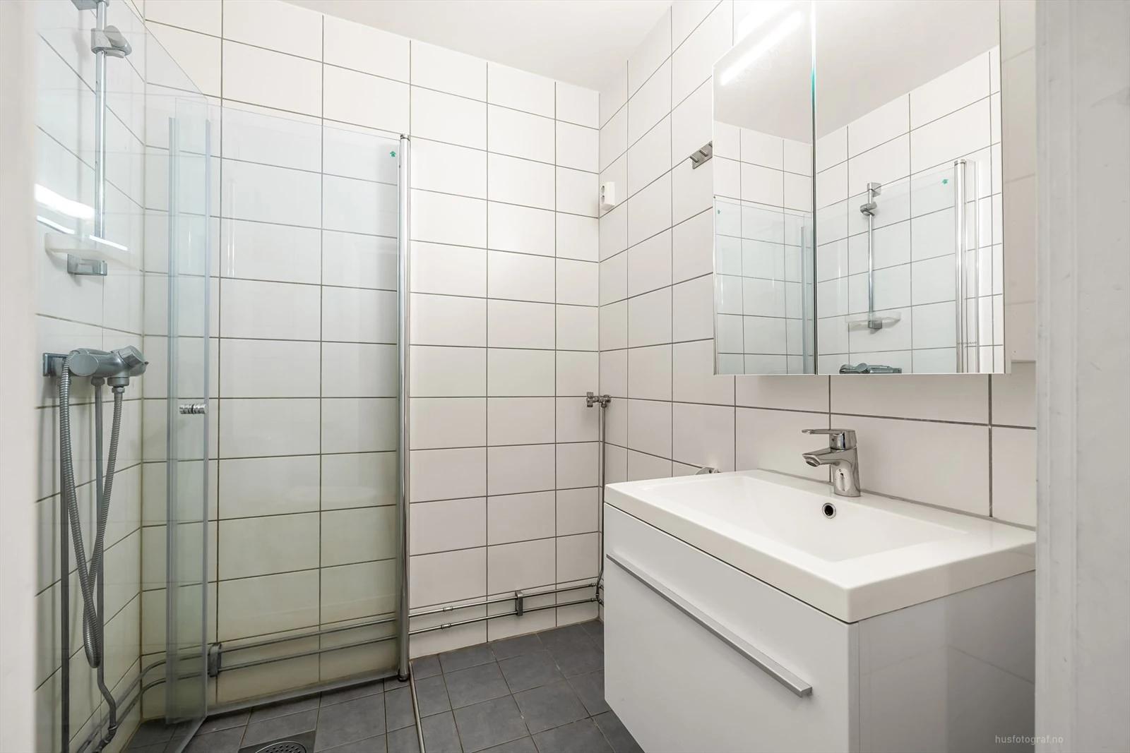 Moderne baderomsinnredning med opplegg for vaskemaskin.
