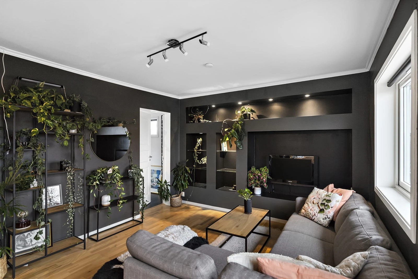 Legg merke til den særegne TV-veggen med innfelte hyller med belysning som bidrar til et stilig uttrykk. Galleribilde