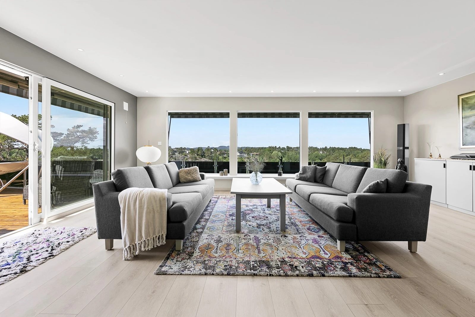 Store vinduer som slipper inn den deilige sola, og rammer inn den nydelige utsikten Galleribilde