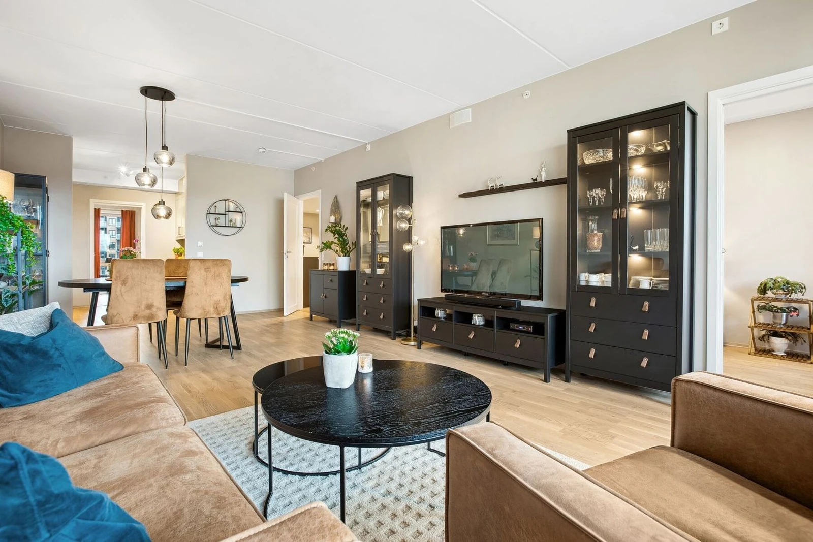 Den romslige stuen er et perfekt sted for både avslapning og sosiale sammenkomster. Med sine smakfulle møbler i varme toner skaper rommet en harmonisk balanse mellom eleganse og funksjonalitet. Galleribilde