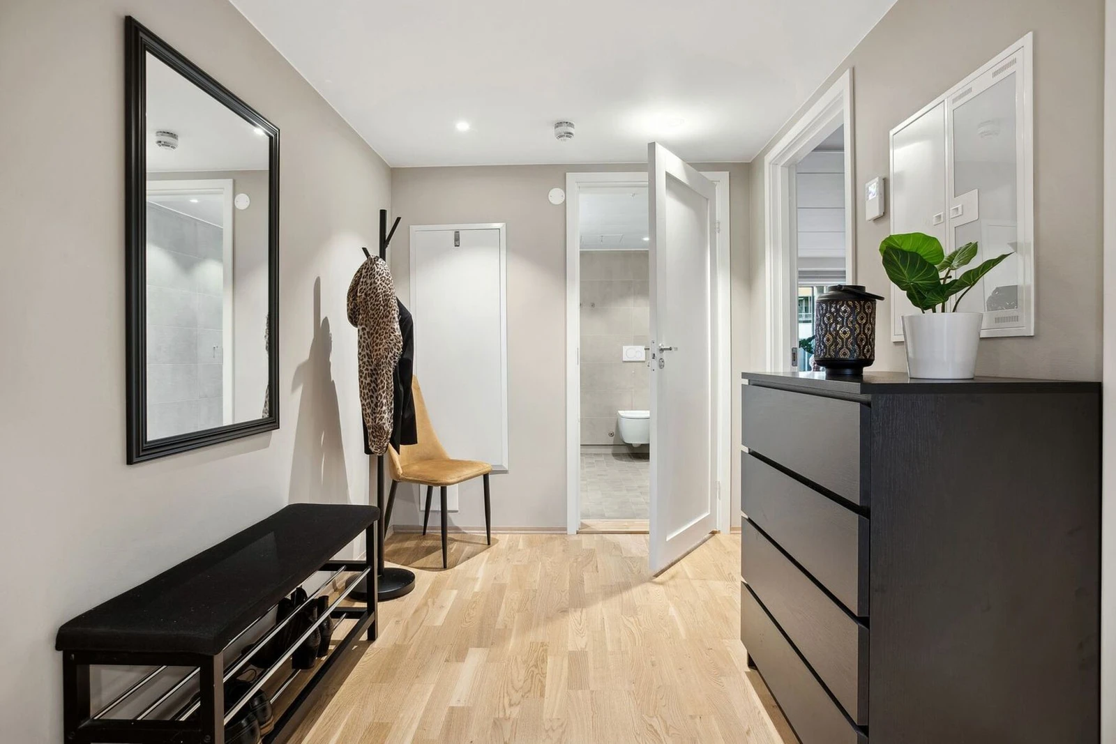 Den romslige gulvplassen gir plass til enkel manøvrering og praktiske oppbevaringsmuligheter, inkludert en skohylle og kommode for å holde alt organisert. Galleribilde