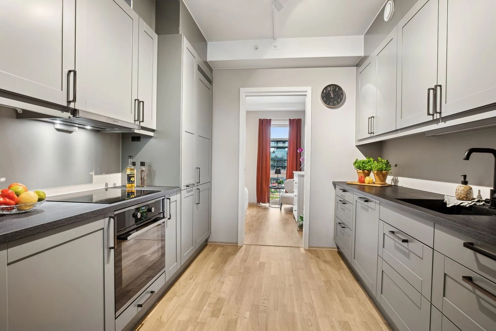 Kjøkkenet imponerer med en elegant og funksjonell design, der de lysegrå fronter harmonerer perfekt med den mørke benkeplaten. Galleribilde