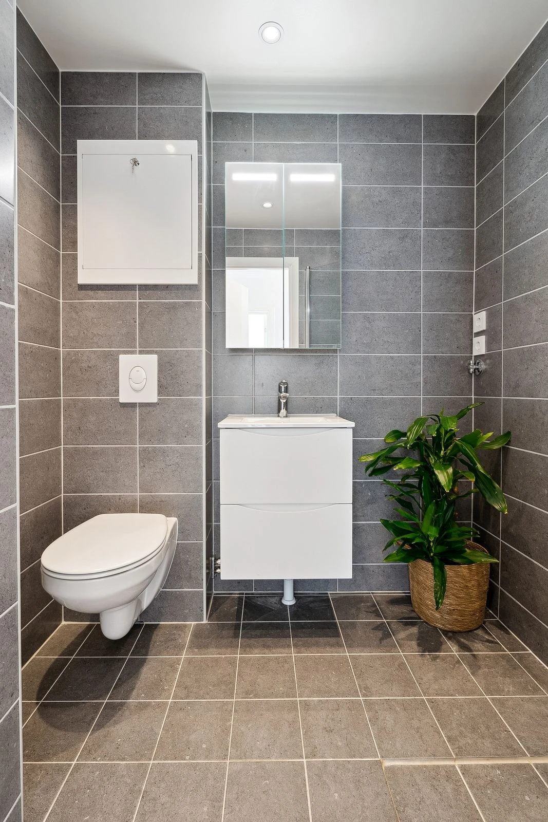 Moderne baderomsinnredning med opplegg for vaskemaskin.