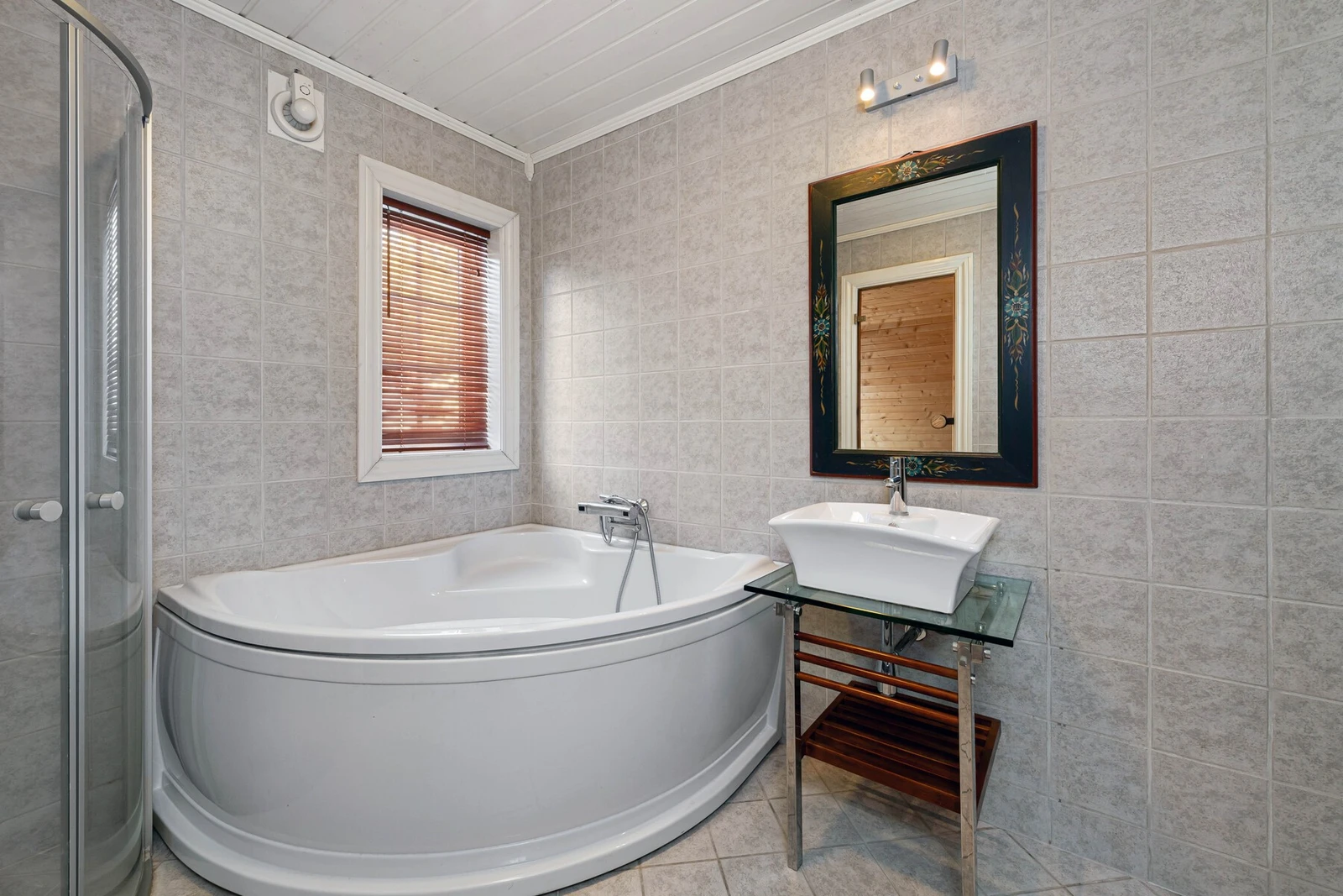 Badet er innredet med badekar, dusj, vask, toalett, badstue og opplegg for vaskemaskin. Galleribilde