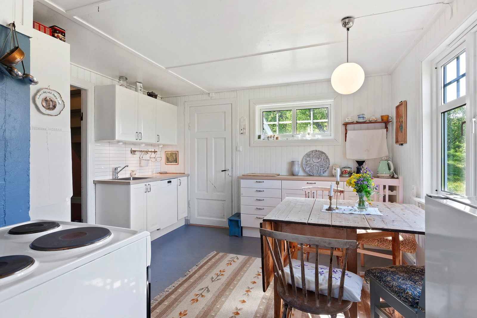 Lys kjøkkeninnredning med skuffer og skap, oppvaskmaskin, komfyr og kjøleskap medfølger. Galleribilde