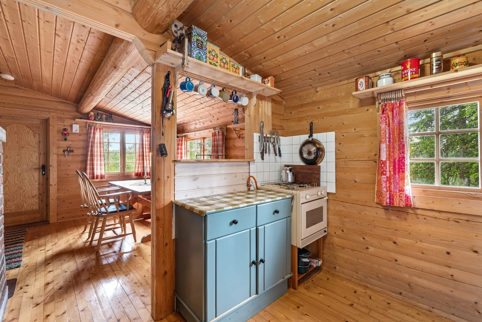 Kjøkkenet er utstyr med kjøkkenbenk, kjøleskap og en ovn. Galleribilde