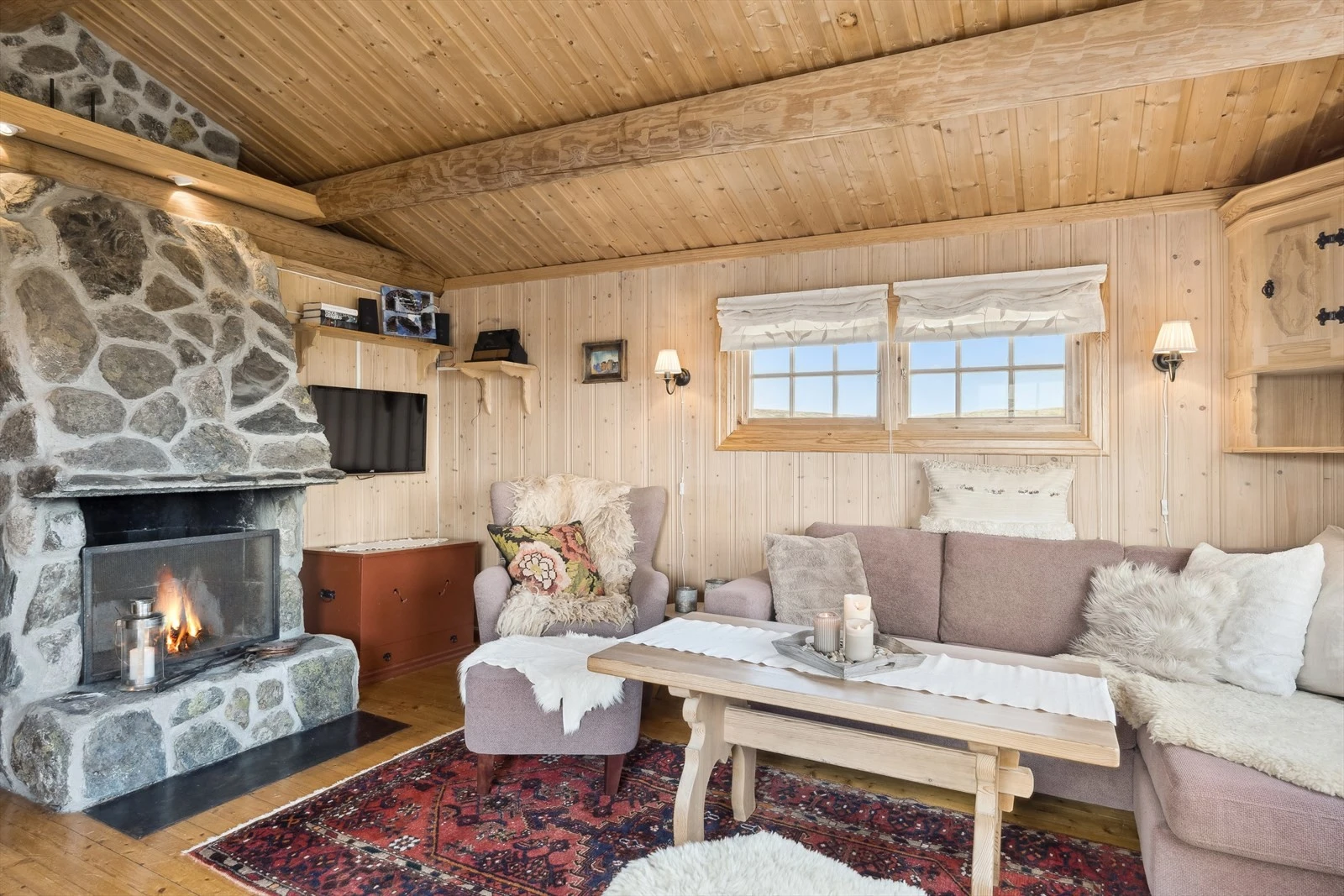 I stua er det mønet himling med flotte tømmeråser, og en plassmurt peis forblendet med naturstein gir en hyggelig stemning til rommet. Galleribilde