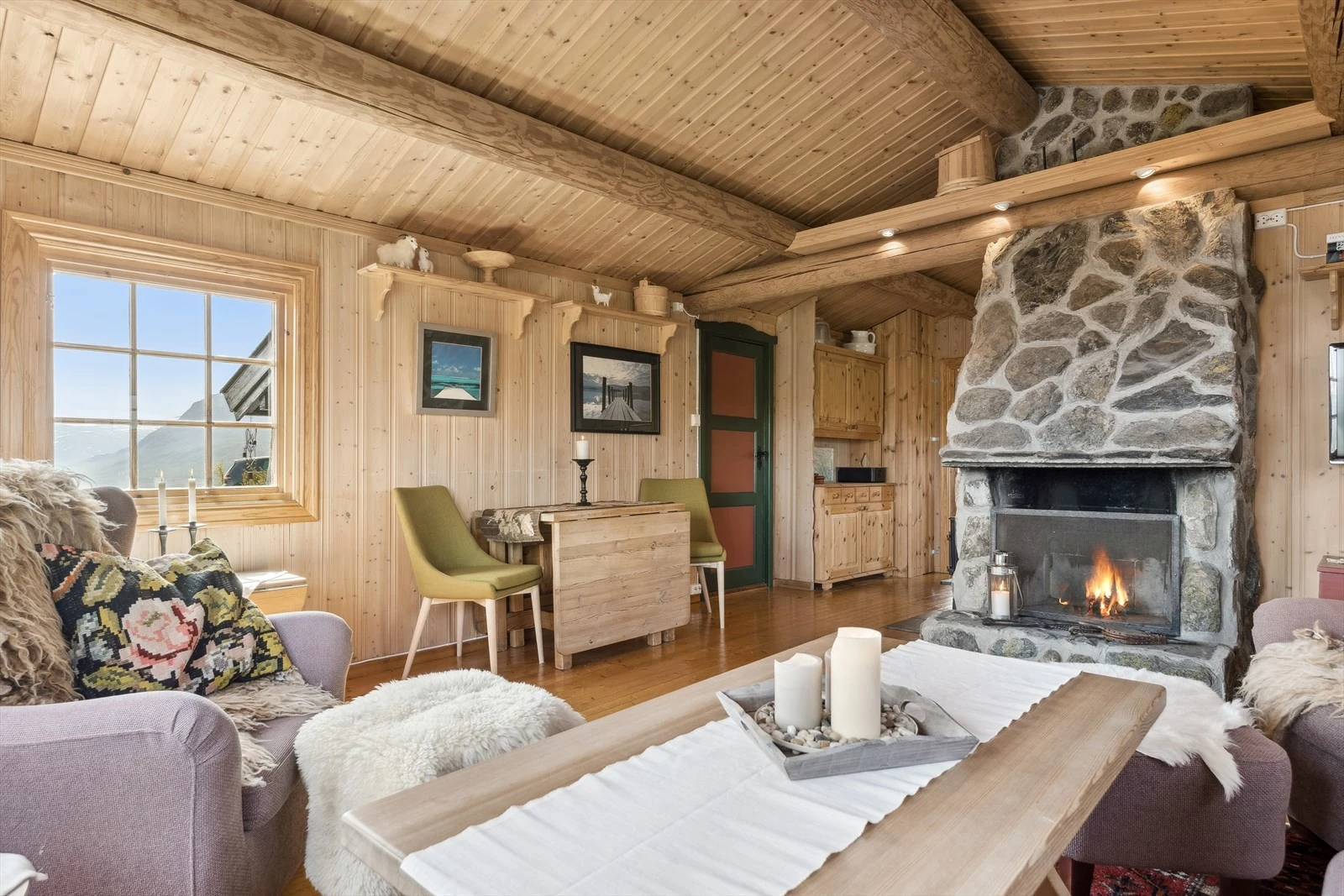 Nær peisen, mot kjøkken, er det en Jøtul vedovn som gir lun og god varme. Galleribilde