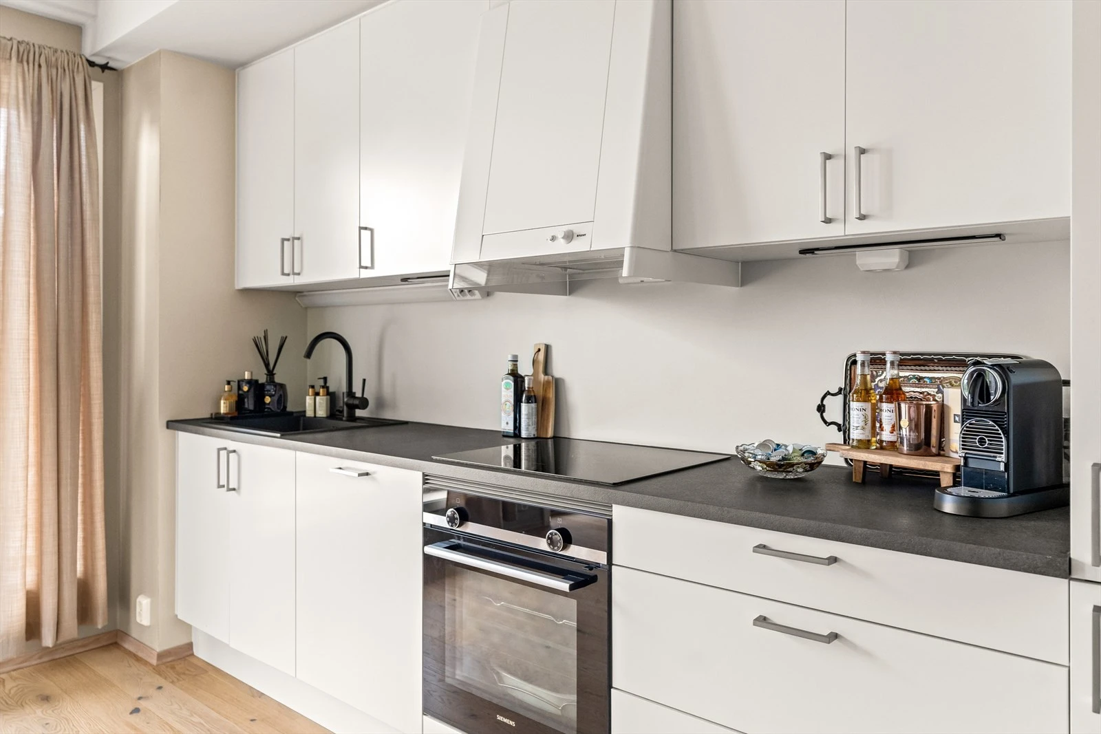 Kjøkkenet er stilrent med mye skap, skuffer og benkeplass, i tillegg til integrerte hvitevarer. Galleribilde