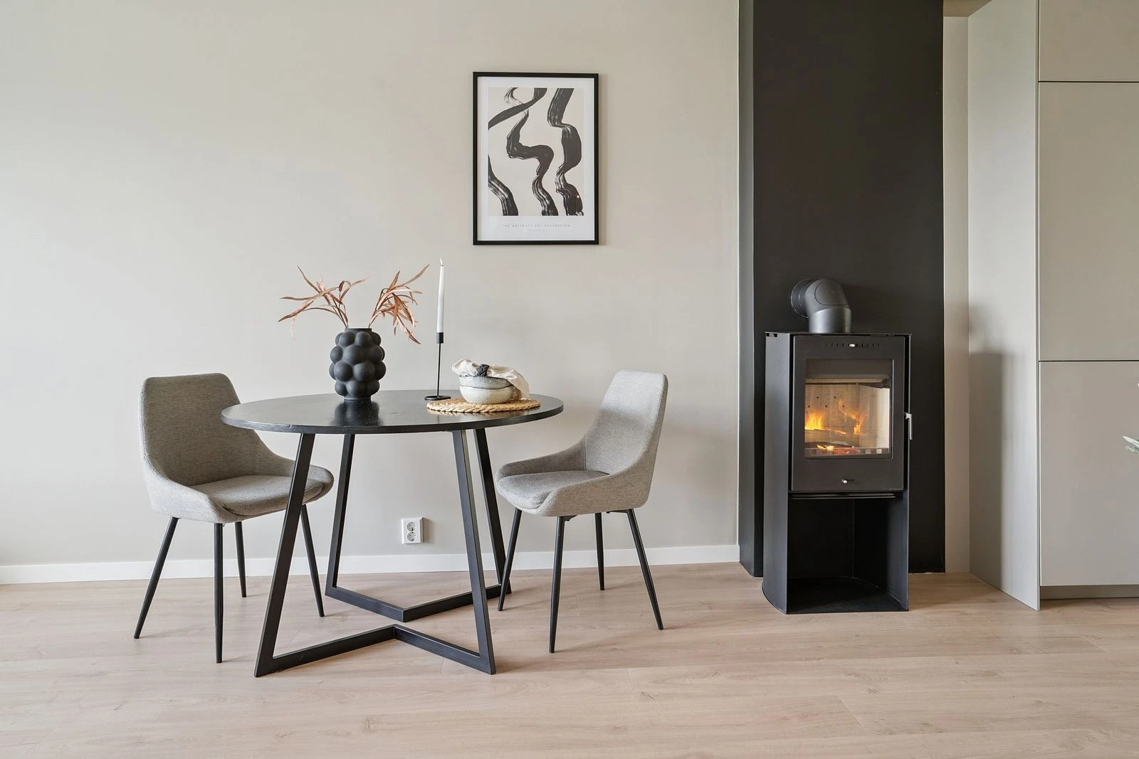 Kombinasjonen av moderne stil og vedovn gir stuen et lunt og innbydende preg.