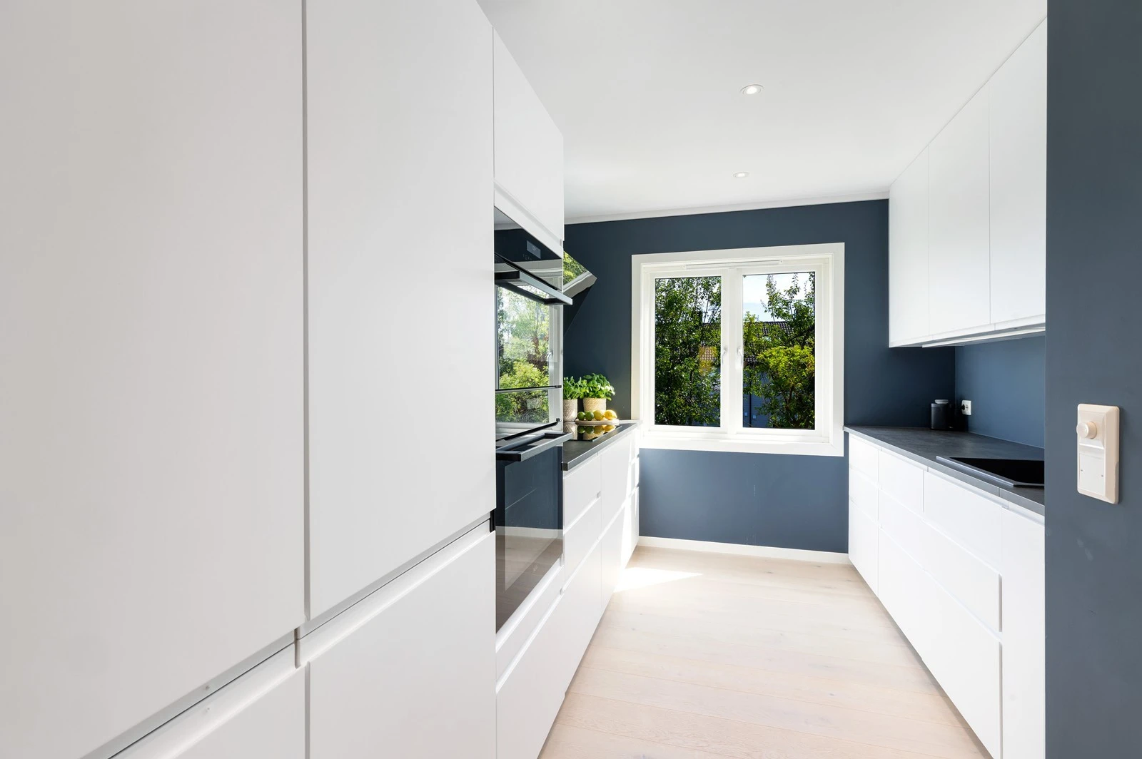 Flott kjøkken med hvite glatte fronter og laminat benkeplate. Galleribilde