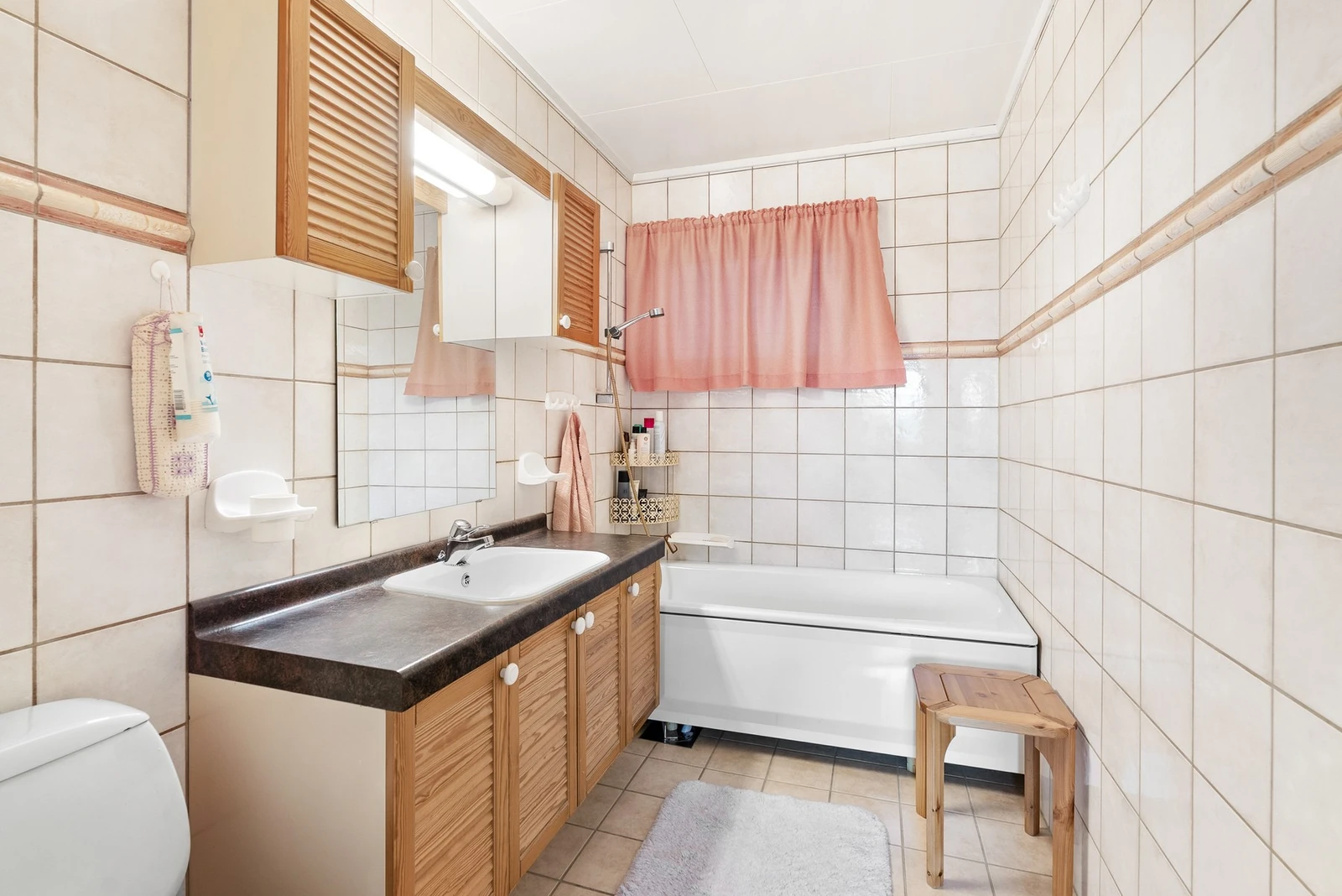 Boligens bad er flislagt med varmekabler i gulvet. Rommet er utstyrt med toalett, romslig servant og badekar med dusjsett. Galleribilde