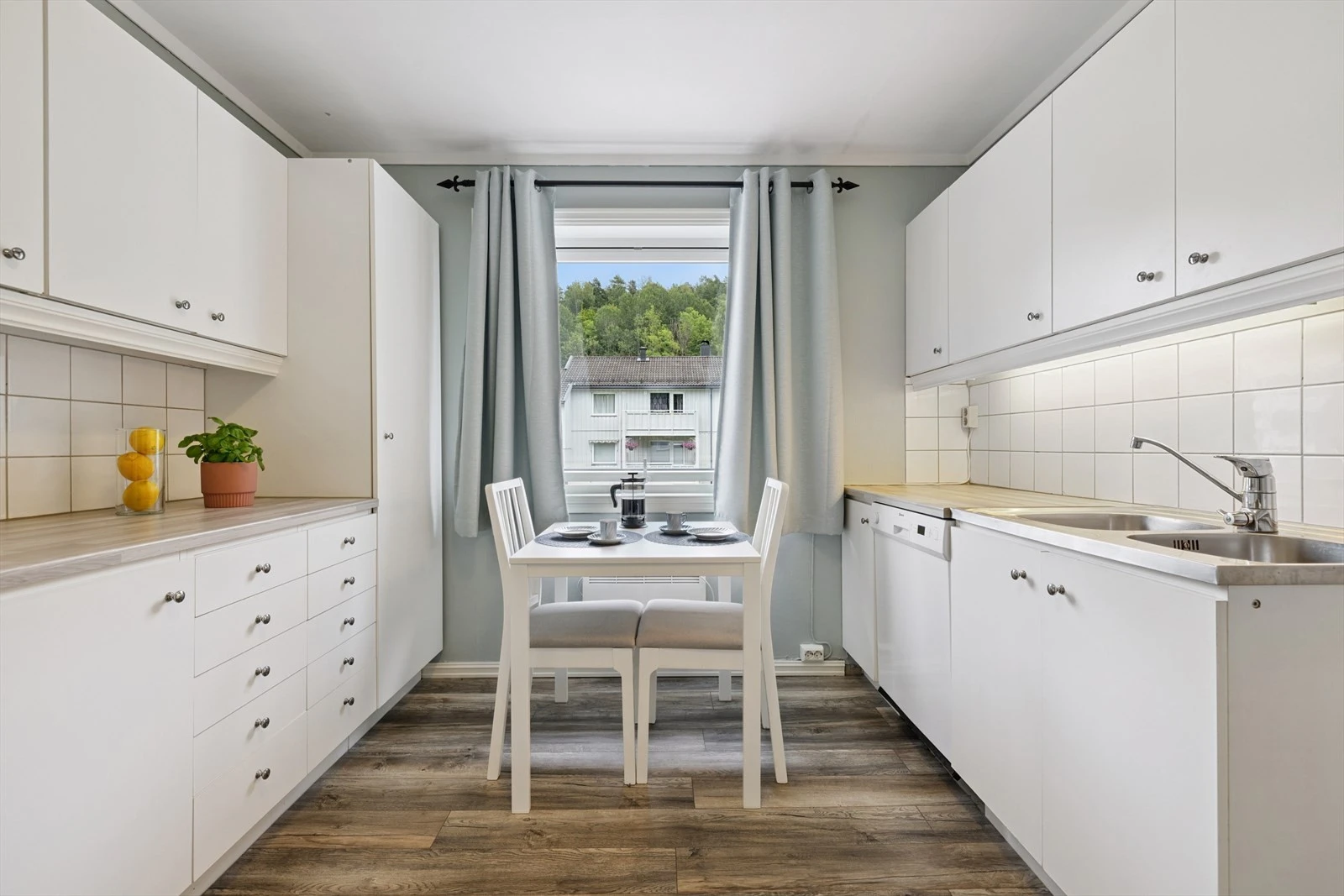 Kjøkkeninnredning med slette lyse fronter og benk i heltre.