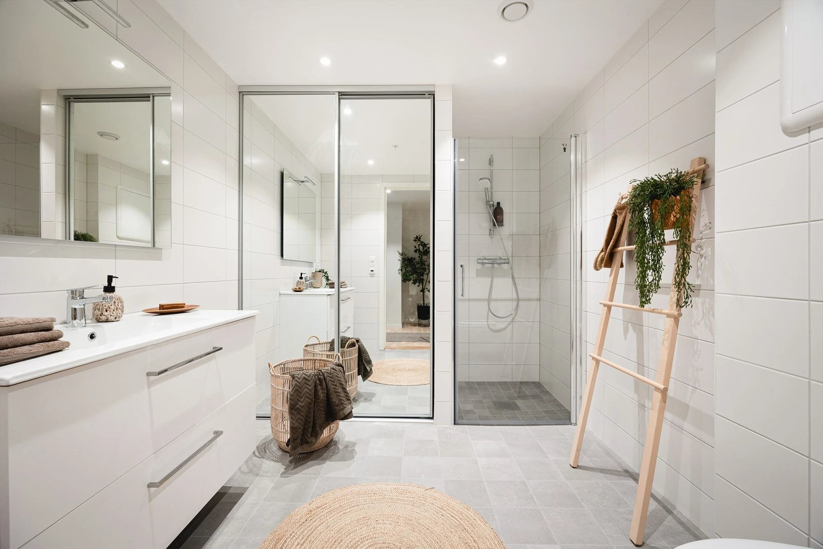 Flott dusjhjørne og opplegg for vaskemaskin i bak skyvedør Galleribilde