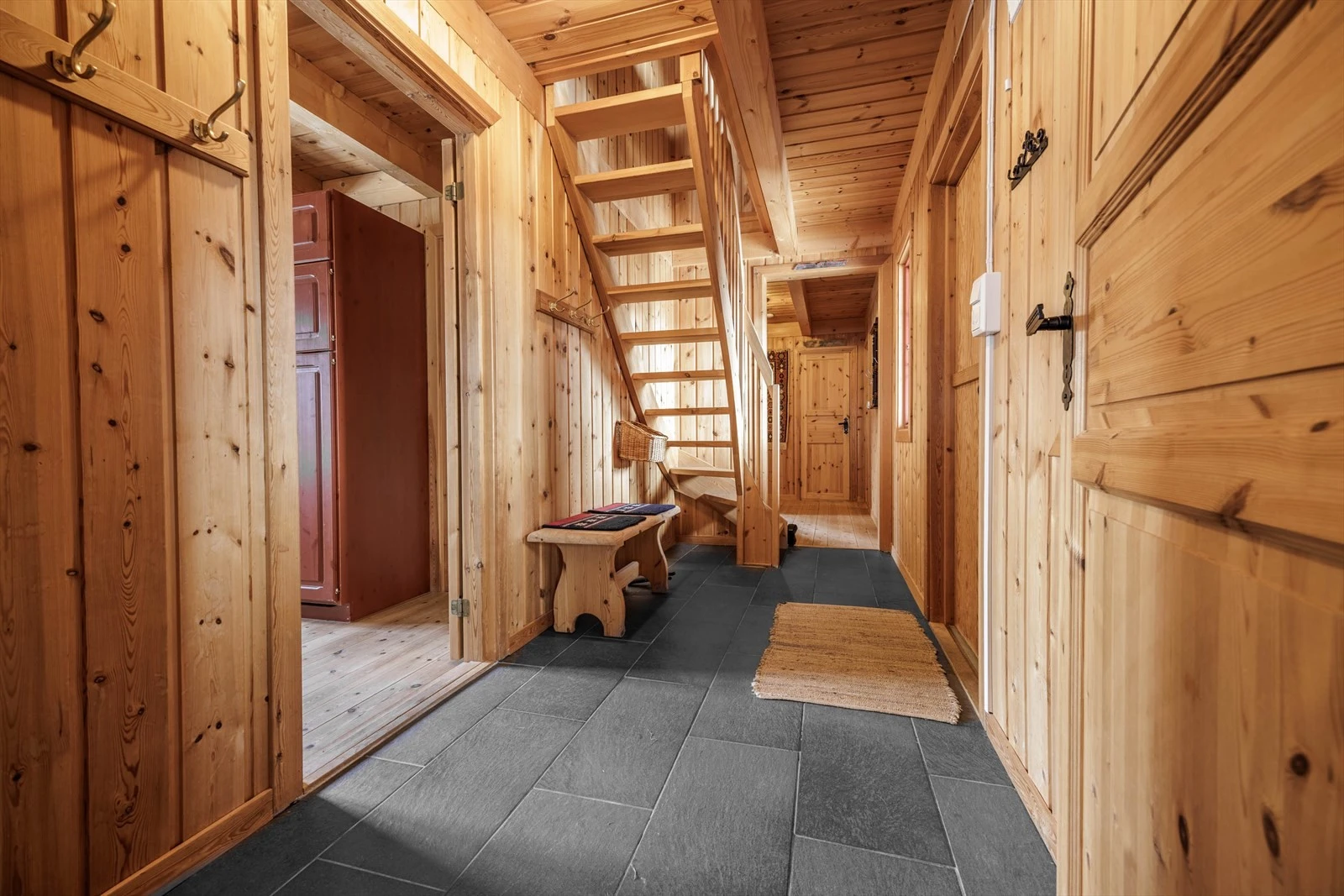Romslig flislagt gang med trapp opp til loftsetasje. Galleribilde