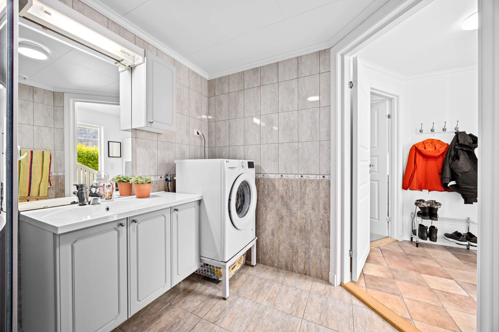 Badet har innredning med nedfelt servant, toalett, dusjkabinett og opplegg for vaskemaskin Galleribilde