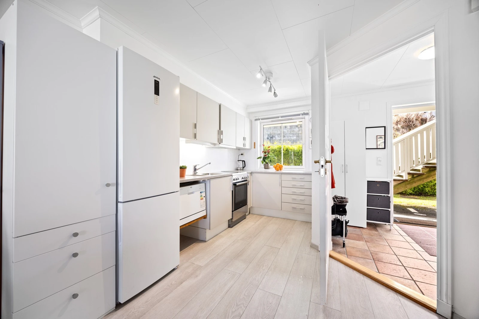 Lyst og trivelig kjøkken som har innredning med glatte fronter, godt med skap- og benkeplass. Galleribilde