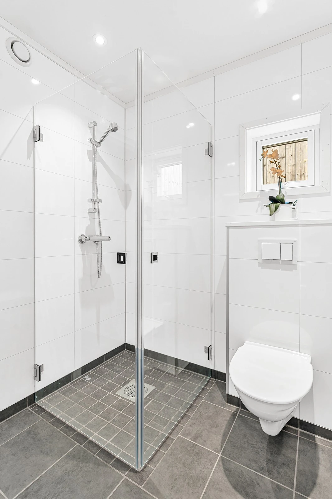 Badet har dusjhjørne og vegghengt toalett. Galleribilde