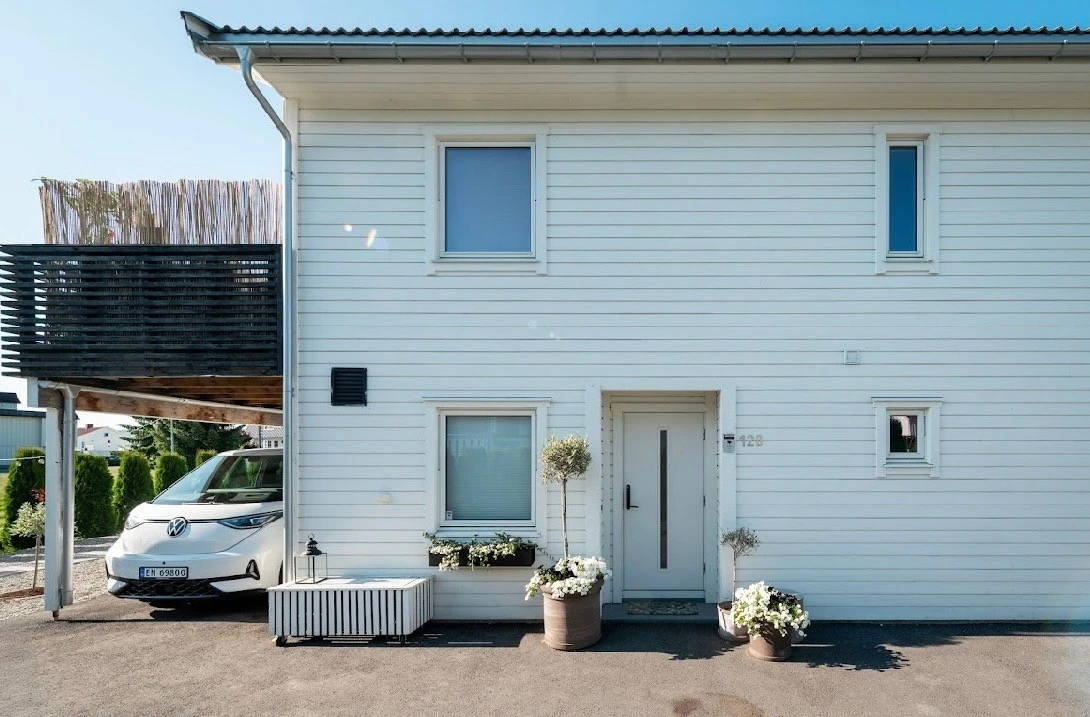 Gårsplass, carport og inngangsparti.