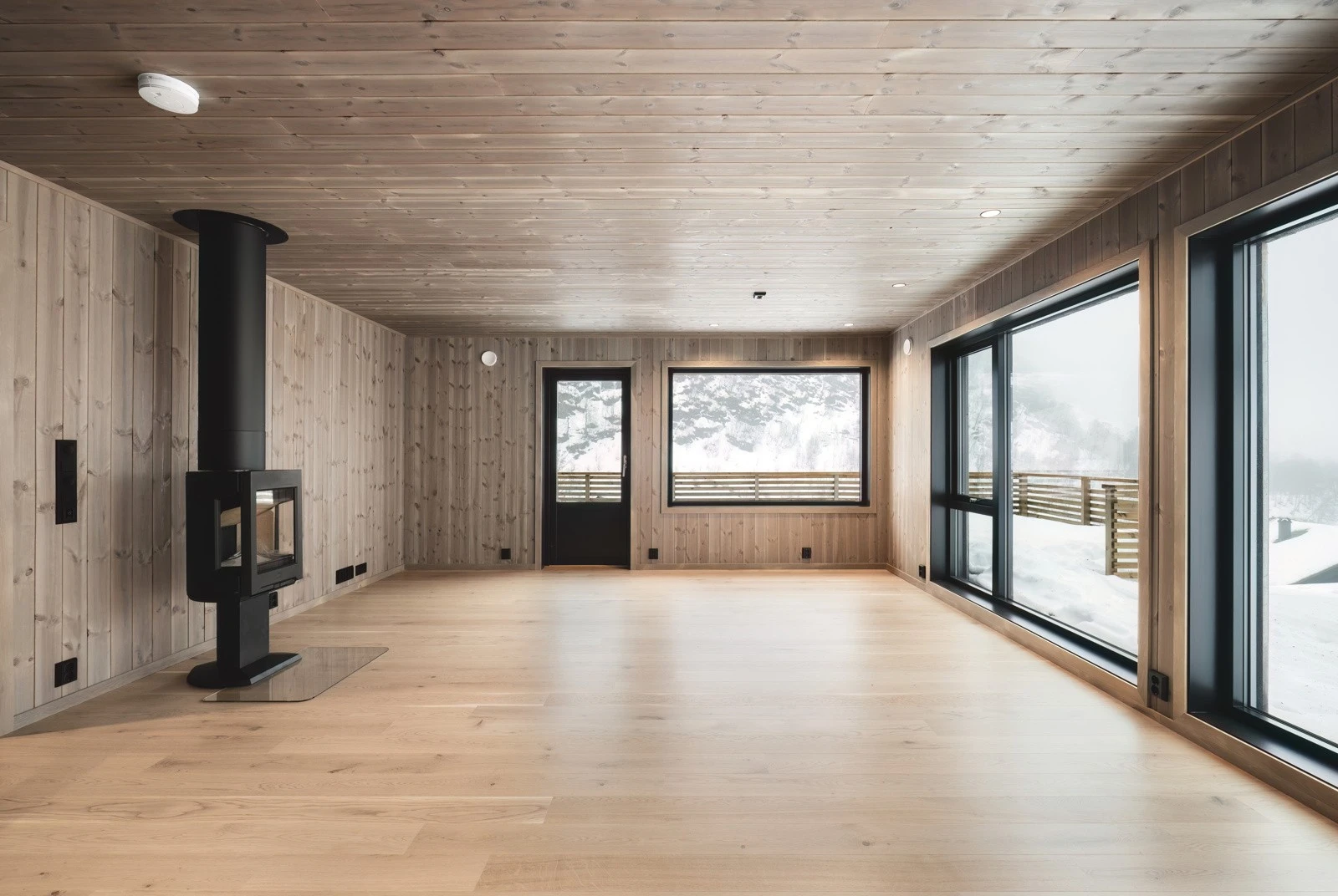 Nydelig stue med store vindusflater som bringer utsikt og dagslys inn i stuen. Galleribilde