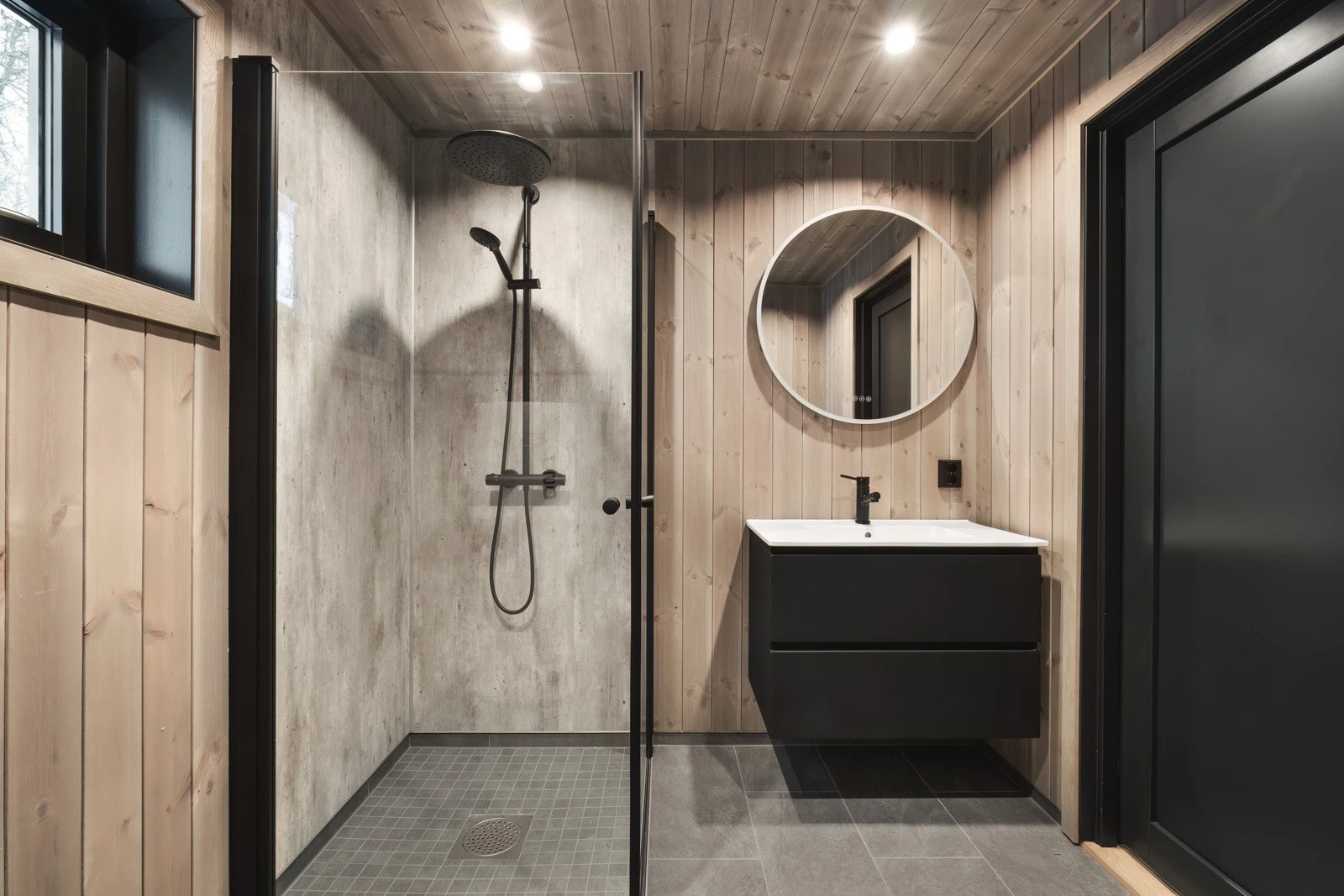 Badet er innredet med vask i seksjon, vegghengt toalett og dusj med glass vegger. Opplegg for vaskemaskin. Galleribilde