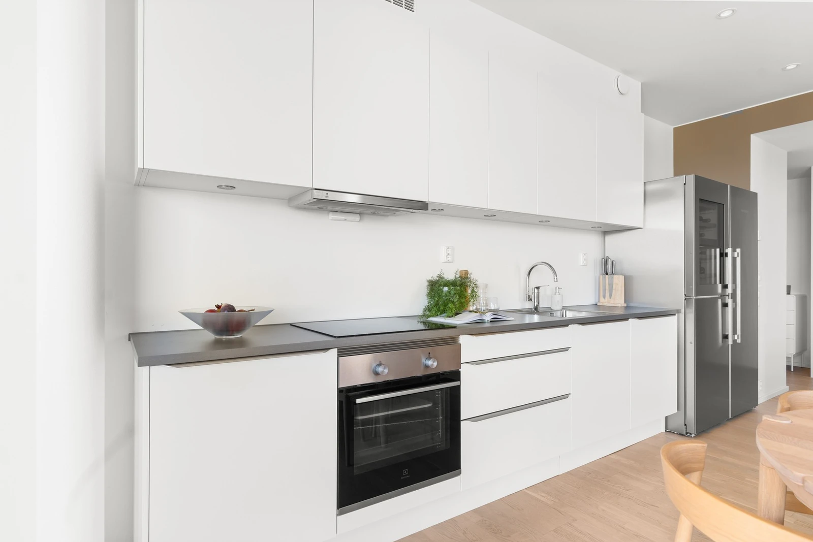 Belysning under overskap. Integrerte hvitevarer som platetopp, stekeovn og oppvaskmaskin. Galleribilde