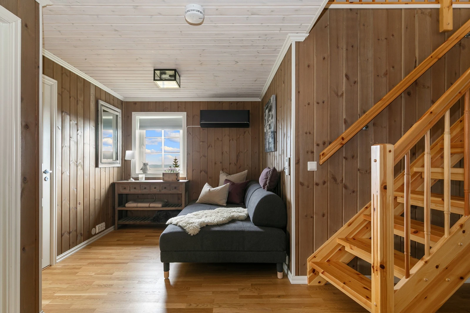 I tilknytning til trapperommet er det plass til en sofagruppe eller hjemmekontorløsning. Her er det også en luft-til-luft varmepumpe som sørger for en jevn temperatur i hele hytta. Galleribilde