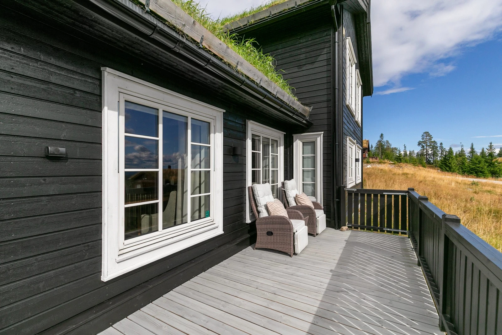 Terrassen slynger seg rundt to sider av hytta. Galleribilde
