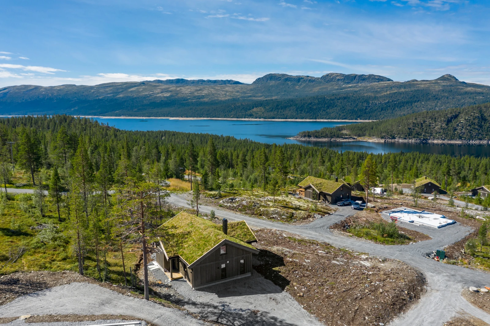 Hytten ligger øverst i feltet, høyt og fritt over nærliggende hytter Galleribilde