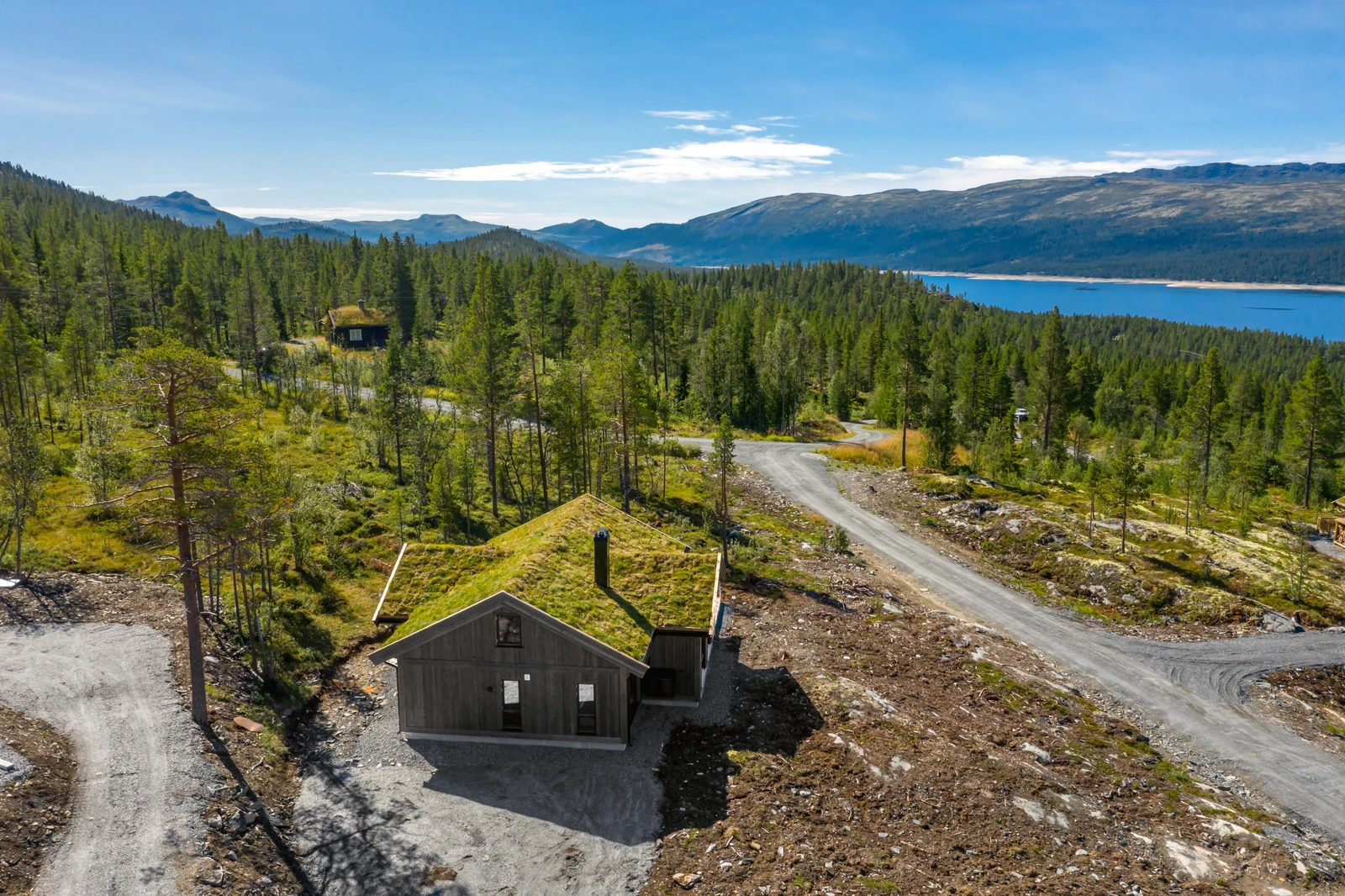 Tomten er pent opparbeidet med parkeringsplass og ellers naturtomt Galleribilde