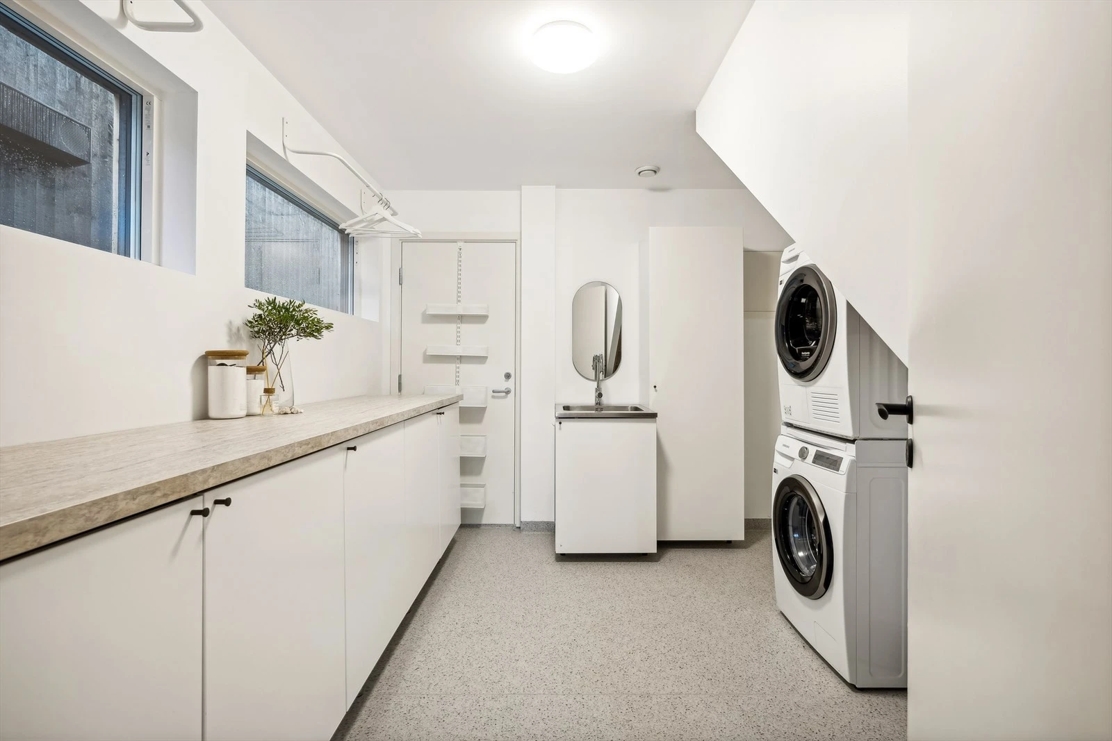 Stor baderomsinnredning og arbeidsflate til klesvasken. Døren er til praktikantdel (som er utleid for kr.10.000,-/mnd). Galleribilde