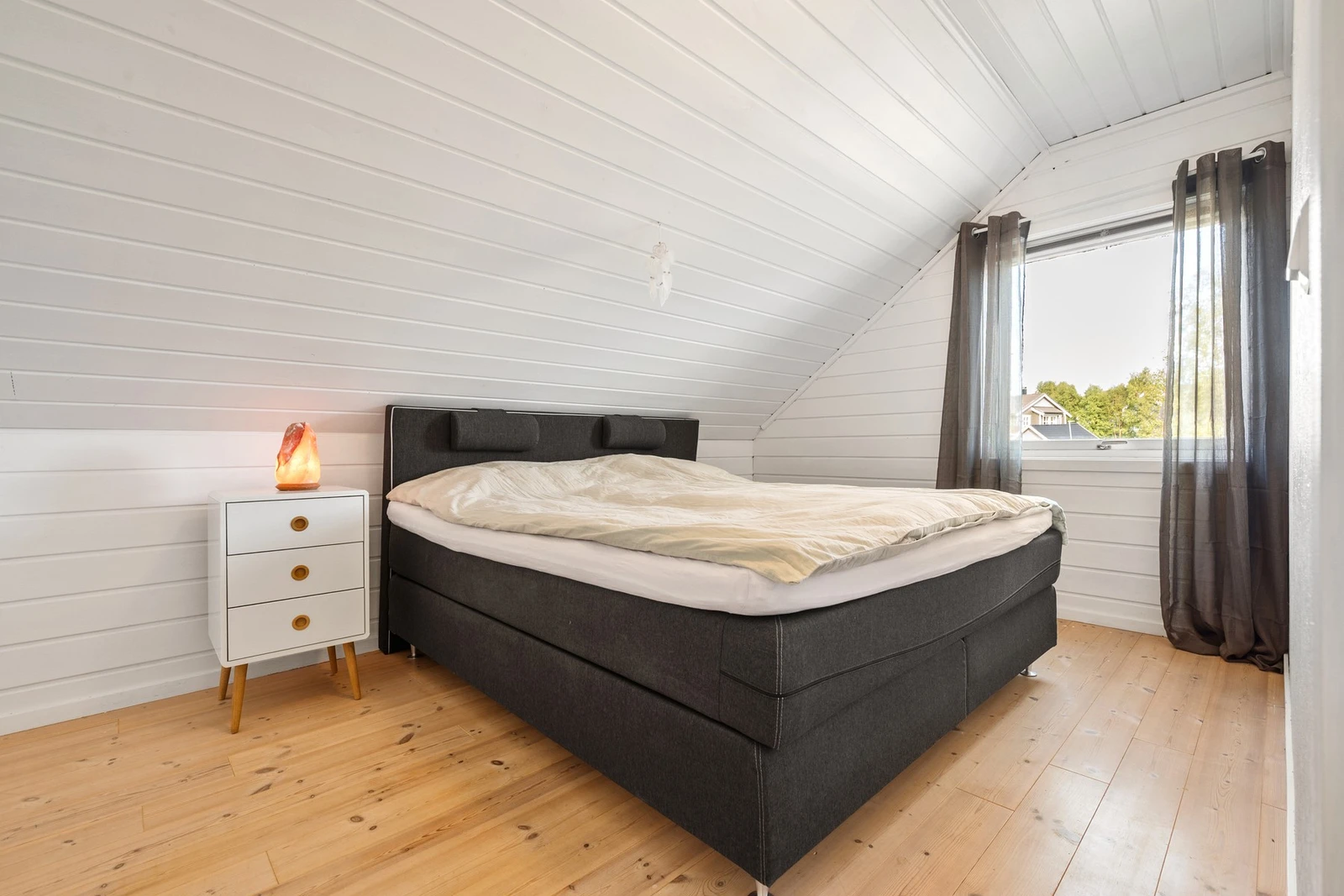 Soverom med god plass til stor dobbeltseng og tilhørende nattbord Galleribilde